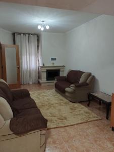 sala de estar con 2 sofás y chimenea en Casa do Ribeiro en Chão de Couce