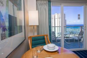 a dining room with a table and a balcony at Amazing view from your balcony Walk to the beach 2420 in Honolulu