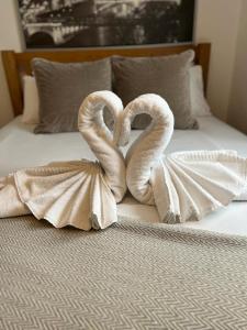two swans wrapped in towels sitting on a bed at 1 Bedroom property in East London in London