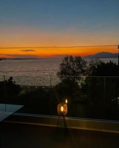 a candle on a balcony with the sunset in the background at Apartment sea view in Chalkida