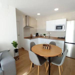 uma cozinha com uma mesa e cadeiras de madeira e uma cozinha com um balcão em Apartamento cerca de Granada em Cenes de la Vega
