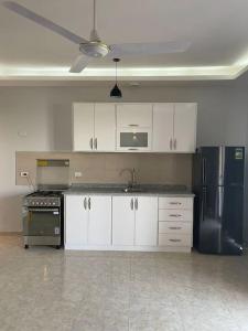 a kitchen with white cabinets and a black refrigerator at Royal Nile Villas - Luxury Nile View Apartment 2 in Luxor +32 photos