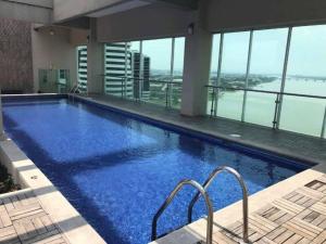 een groot zwembad in een gebouw met uitzicht bij Suit 504, vista al Rio ,con Piscina. in Guayaquil