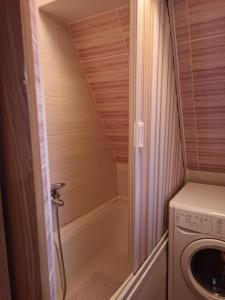 a small bathroom with a washing machine and a washer at SKY APARTMENTS in Kumanovo