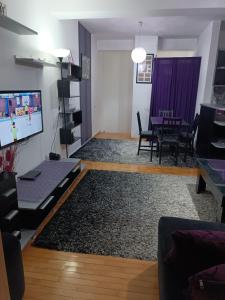 a living room with a tv and a table at SKY APARTMENTS in Kumanovo