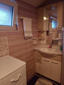 a small bathroom with a sink and a mirror at SKY APARTMENTS in Kumanovo