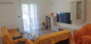 uma sala de estar com um sofá e uma televisão em Casa vacanze Il Girasole em Bagheria
