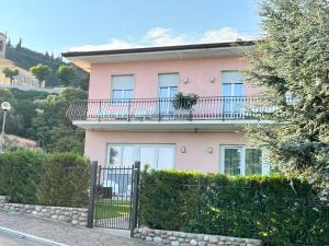 una casa rosa con balcone sopra di Residenza Al SoGno - on Lake Garda a Cavaion Veronese