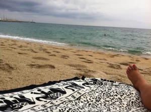 una persona tirada en una toalla en la playa en Oasis Near Barcelona Pool Tennis Beach, en Sant Andreu de Llavaneres