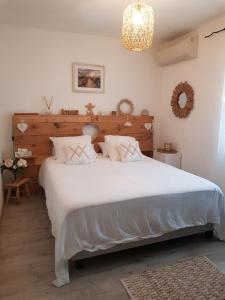 Un dormitorio con una gran cama blanca y una lámpara de araña. en Magnifique villa de charme avec piscine en Draguignan