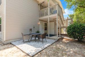a patio with a table and chairs next to a house at Gulf Breeze Home/Remodeled 2Bdr in Gulf Breeze