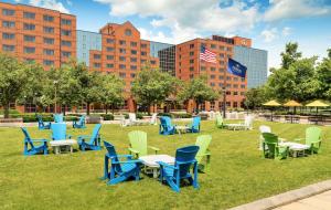 un groupe de chaises et de tables sur l'herbe dans un parc dans l'établissement Hilton Short Hills, à Short Hills