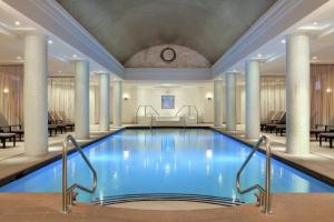 uma piscina no átrio do hotel com colunas em Hilton Short Hills em Short Hills