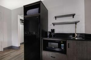 a kitchen with a black refrigerator and a microwave at Studio 6 San Antonio TX Northwest Medical Center in San Antonio