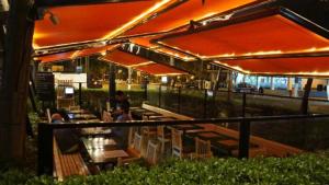um restaurante com guarda-sóis laranja, mesas e cadeiras em Departamento de Estreno en Barranco em Lima