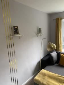 a bedroom with a bed and a gold lamp at 18K HOME FROM HOME in London
