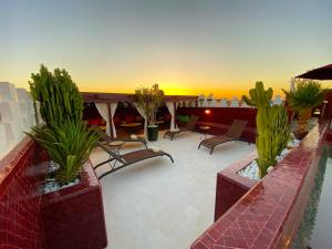 een patio met stoelen en planten op een dak bij Riad La Perle Rouge in Marrakesh