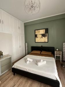 a bedroom with a bed and a chandelier at Cozy Apartment with parking near the city center in Athens