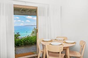 a dining room with a table and a view of the ocean at Beach View Mollymook in Mollymook