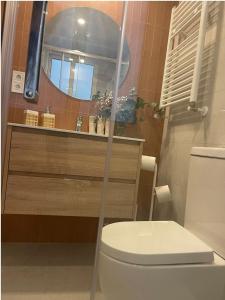 y baño con aseo blanco y espejo. en APARTAMENTO 4 PAX RECIÉN REFORMADO EN EL CENTRO DE SANTANDER, en Santander