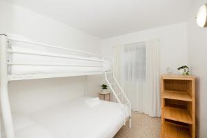 a bedroom with a white bunk bed and a wooden cabinet at Beach View Mollymook in Mollymook