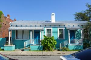 una casa azul con un techo de estaño en una calle en Stella Blue - A en Savannah