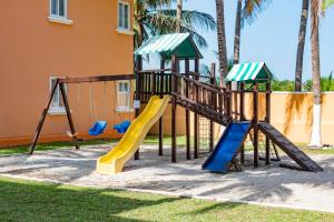 un parque infantil con un tobogán en un patio en Hotel Cayman Suites, en Monterrico