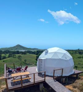 een grote witte tent op een houten terras bij Domescape Glamping in El Cedro