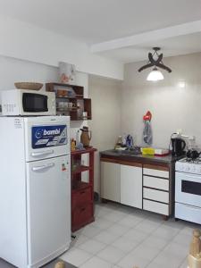 a kitchen with a white refrigerator and a counter at Dpto AR in San Clemente del Tuyú