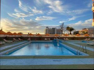 een groot zwembad in het midden van een resort bij Sweet home deluxe in Playa de las Americas