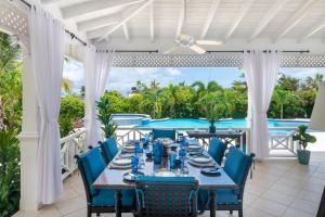 a dining room with a table and chairs and a pool at Sugar Hill - Fiddlesticks villa in Saint James