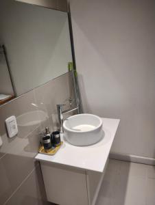 a white bathroom with a sink and a mirror at Zencity in Buenos Aires +2 photos
