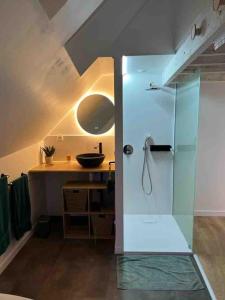 een badkamer met een glazen douche en een wastafel bij Le Cocon des Remparts-Logis Élégant à Pierrefonds in Pierrefonds