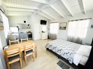 a bedroom with a bed and a desk and a kitchen at Pedazo del Mar Beach House in Salinas