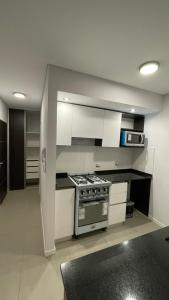 a kitchen with white cabinets and a stove top oven at Dorrego in Rosario