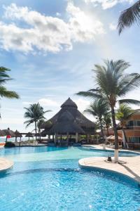 una piscina con palmeras y un complejo en Hotel Cayman Suites, en Monterrico