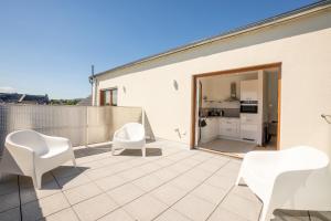 a patio with white chairs and a kitchen at Möbliertes Wohnen I Eltville central in Eltville