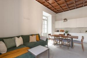een woonkamer met een groene bank en een tafel bij MC House Como con Posto Auto in Como