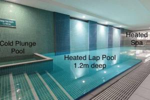 a swimming pool in a building with blue tiles at Absolute Beachfront at the Pier Glenelg in Adelaide