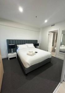 a bedroom with a large white bed with a mirror at Absolute Beachfront at the Pier Glenelg in Adelaide +34 photos