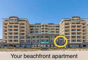 a large building with a yellow circle in front of it at Absolute Beachfront at the Pier Glenelg in Glenelg