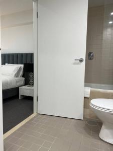 a bathroom with a toilet and a bed at Absolute Beachfront at the Pier Glenelg in Adelaide
