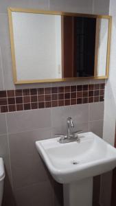un baño con lavabo y espejo en Hostal Santo Domingo, en Puebla