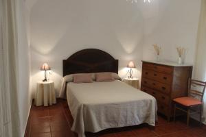 una camera con un letto e un comò e due lampade di Casa Rural El Nini a La Coronada