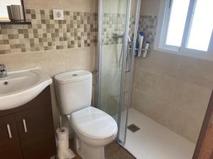 un bagno con wc, lavandino e doccia di Casa Rural El Nini a La Coronada Altre 15 foto