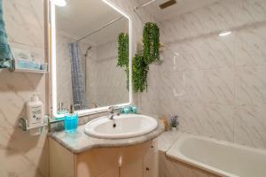 a bathroom with a sink and a tub and a mirror at La Garita Vista azul in La Garita