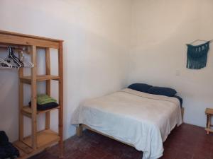 - une chambre avec un lit et une étagère dans l'établissement El Rinconcito de San Cris, à San Cristóbal de Las Casas