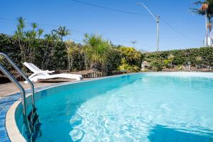 a swimming pool with a chair and palm trees at The Marco Polo in Mackay