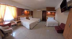 HOTEL Javier Prado Inn في ليما: غرفة فندقية بسريرين ومكتب