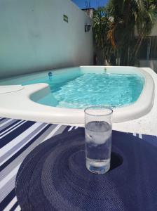 un verre d'eau assis sur une table à côté d'une piscine dans l'établissement Casa Carmen, à Playa del Carmen
